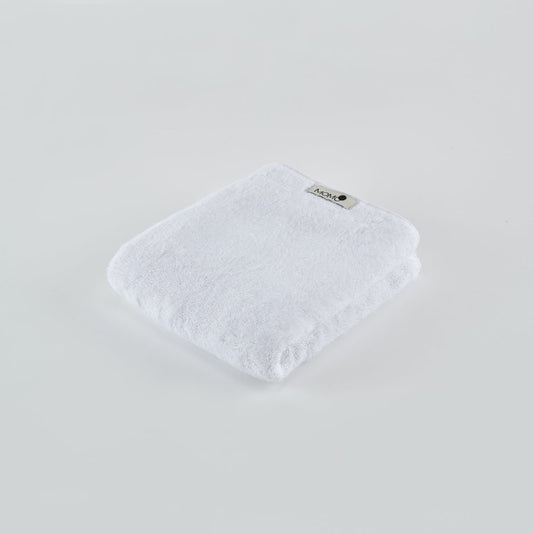 White bamboo towel by Momo Cotton folded on light background with brand label visible