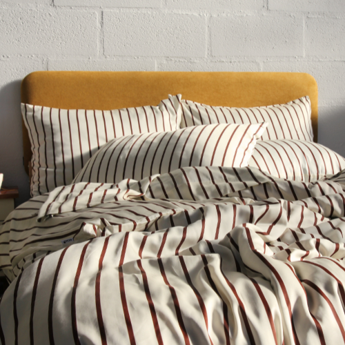 Bamboe beddengoed set met streeppatroon op bed met geel hoofdbord