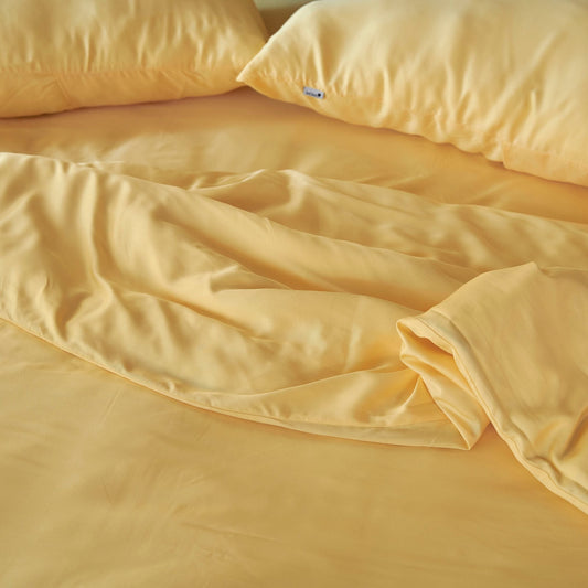 Jogo de capa de edredão em bambu creme exibido na cama mostrando textura de tecido macio e sedoso e cor bege natural