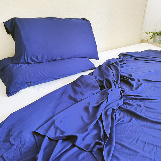Jogo de cama de bambu azul-marinho e branco na cama – lençol e fronhas, macio, respirável e sustentável