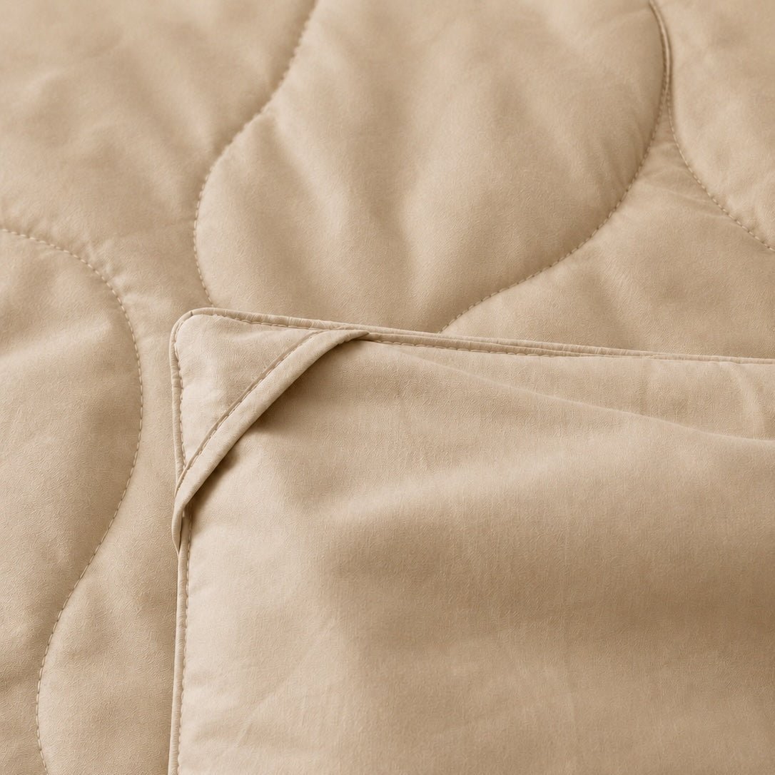 Beige gewatteerde zomerspreid met gestikt patroondetail, zachte katoenen stof textuur en vouwen
