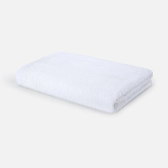 Witte gevouwen badhanddoek op neutrale achtergrond, Wabi-sabi design Momo Cotton, 70x140cm