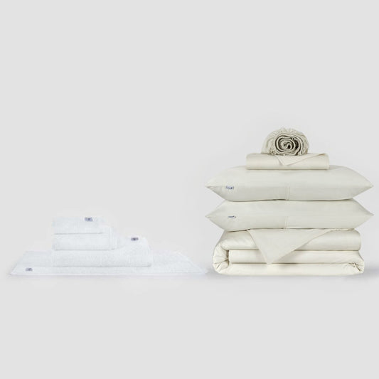 Momo Cotton compleet beddengoed- en handdoekcollectie in crème met netjes opgeouwen beddengoed en handdoeken op witte achtergrond