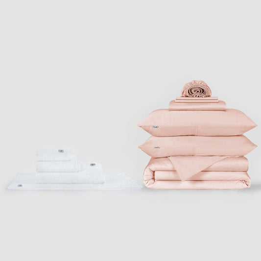 Witte handdoekenset en roze beddengoed set met decoratief kussen op neutraal achtergrond van Momo Cotton