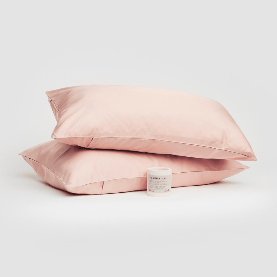 Paar roze katoenen kussenslopen weergegeven met Somnia 1.0 product op witte achtergrond