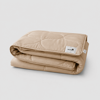 Beige gewatteerde zomersprrei gevouwen met zichtbare Momo-label op witte achtergrond
