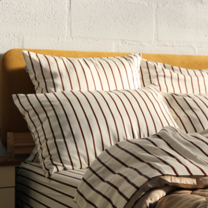 Bamboe beddengoed met strepen en bijpassende kussens op lichthout bedframe