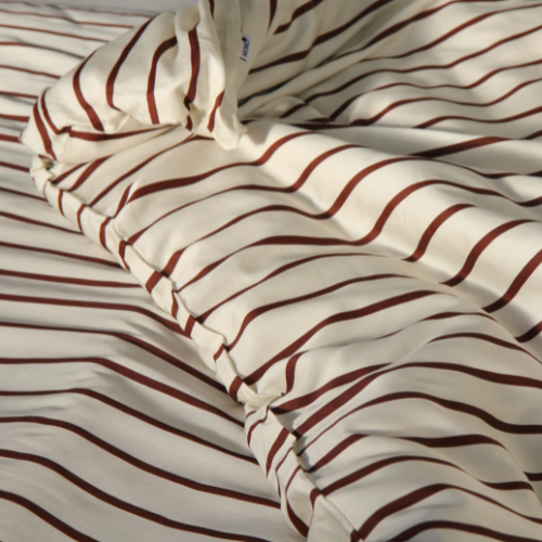 Bamboe beddengoed set met rood-witte strepen op bed