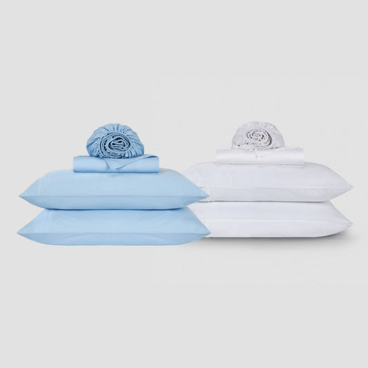Blauw-wit katoenen beddengoed met kussens en opgerolde bedding op neutrale achtergrond