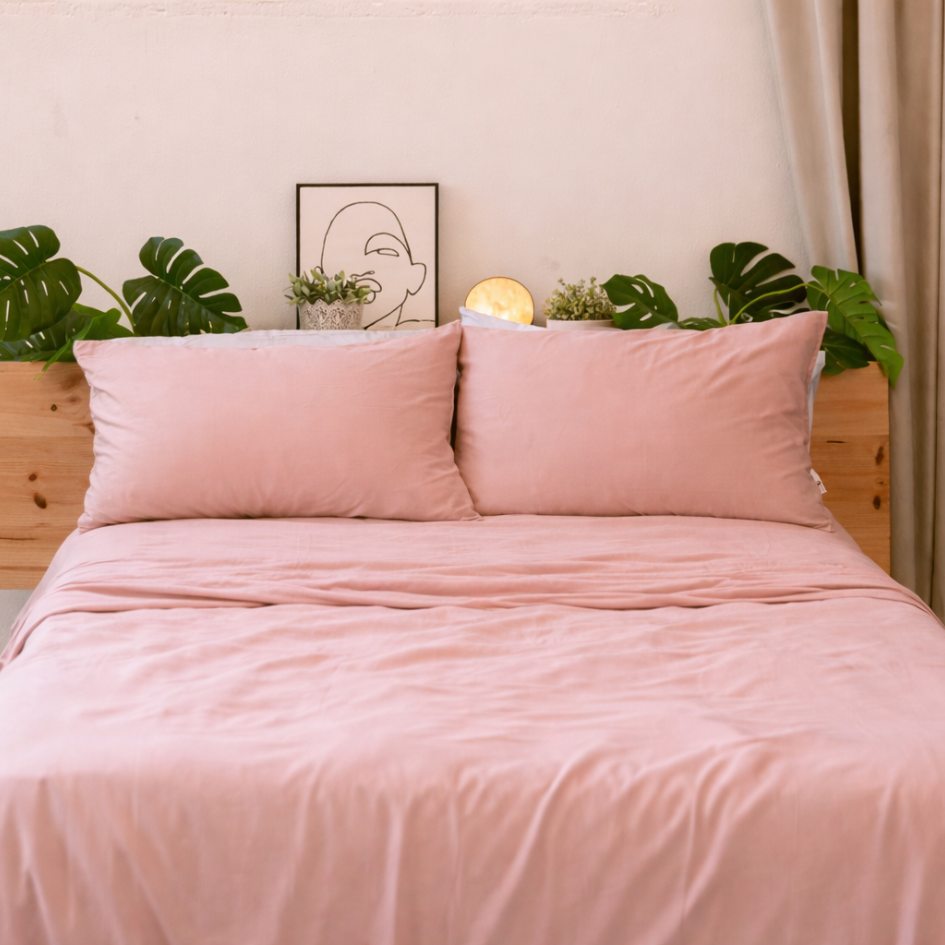 Soft pink bamboo bedding neatly made, highlighting the smooth and elegant drape of the fabric.